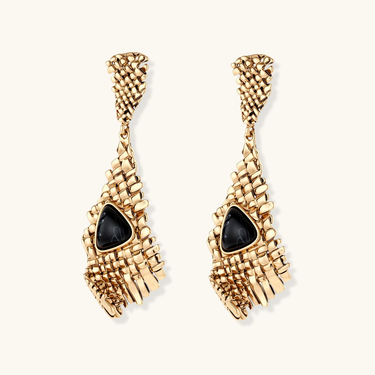 Gold-toned geometric mesh earrings with black triangular resin stones and fringe detail on neutral background