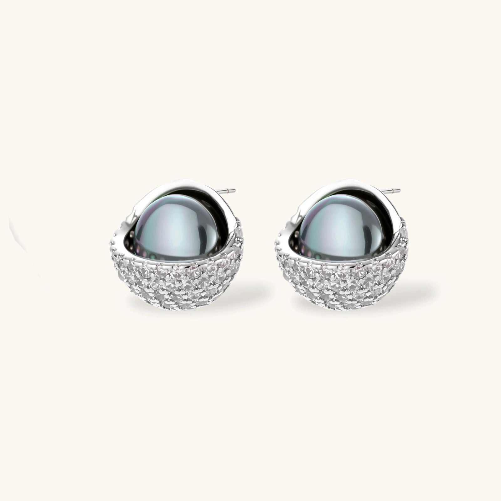 Silver gray Tahitian-style pearl pendant necklace and matching pave zirconia stud earrings set on cream background.